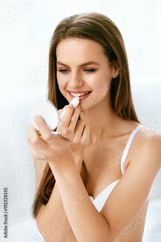 Beauty. Woman With Beauty Face Applying Lip Balm