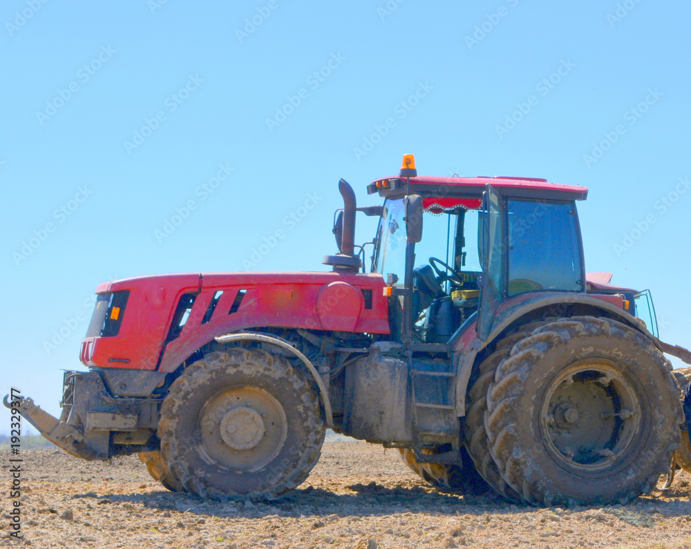 Red modern tractor on the field Red modern tractor on the field