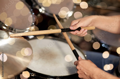 male musician hands with drumsticks at concert