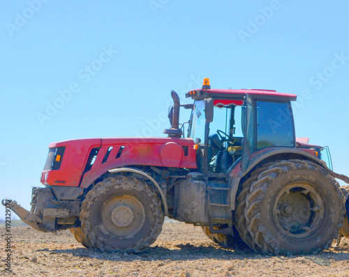 Red modern tractor on the field