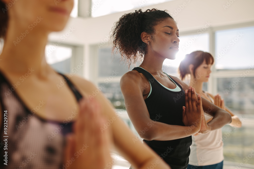 Woman practice yoga with friends in gym - obrazy, fototapety, plakaty 