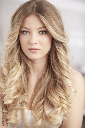 blonde girl with long curl hair and blue eyes portrait