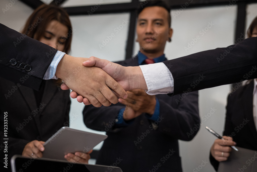 Business people shaking hands after finishing up meeting. co worker colleagues handshaking after conference. teamwork, partnership, collaboration, corporate concept.