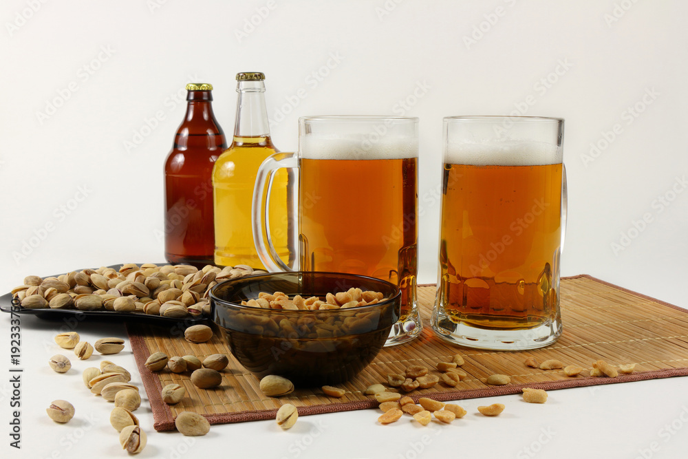 Still life with beer mugs and pistachios in light colors Still life with beer mugs and pistachios in light colors