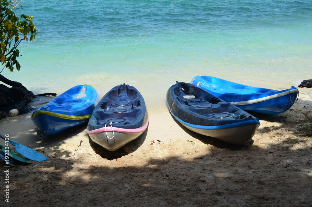 Kayak boat on the beach with blue sea, under shady Kayak boat on the beach with blue sea, under shady