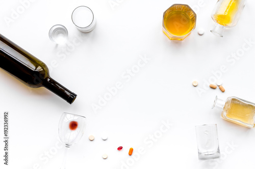 Alocohol abuse and alcoholism treatment concept. Glasses, bottles and medcine pills on white background top view copy space photo