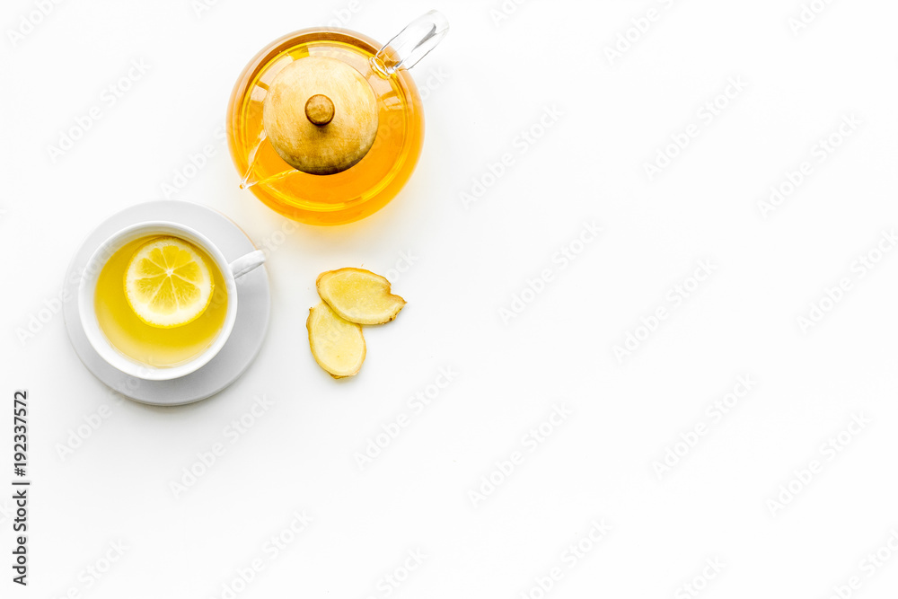 Warming tea with lemon and ginger. Cup, teapot, ginger root on white background top view copy space