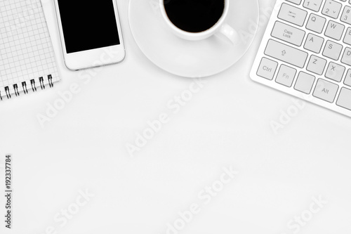 Office desk table with notepad, phone, coffee cup and keyboard computer