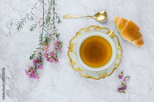 Breakfast table with cup of tea and croissant