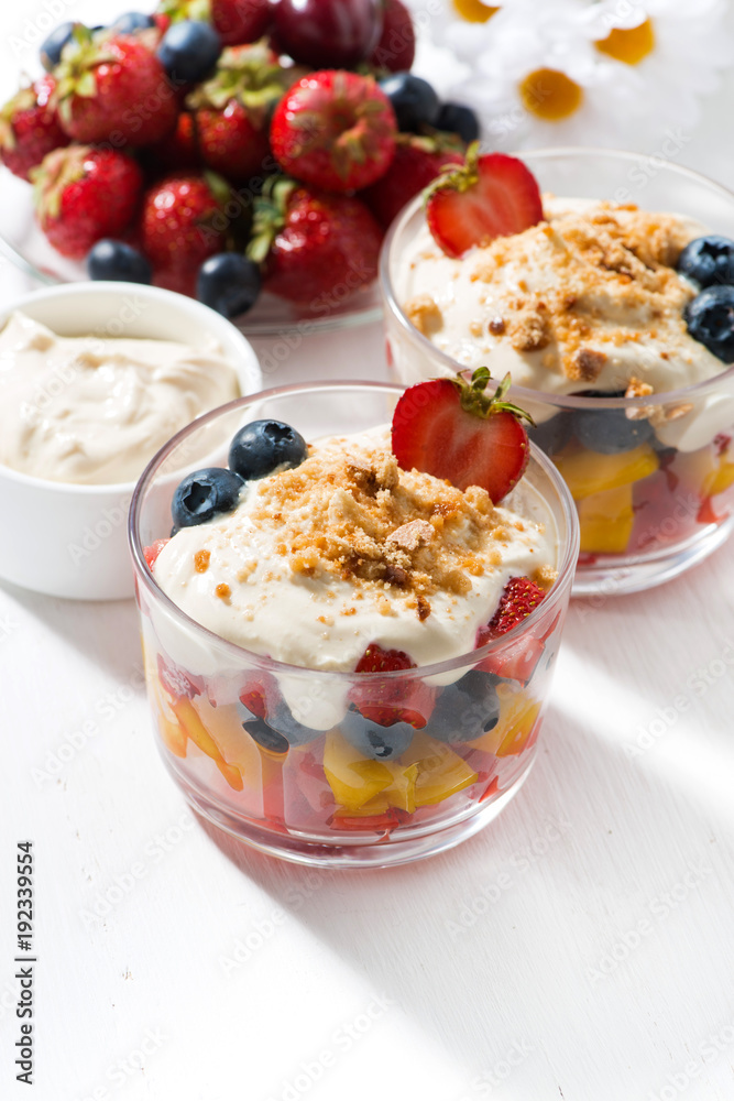 Assorted fresh fruit with custard on white table, vertical, top view