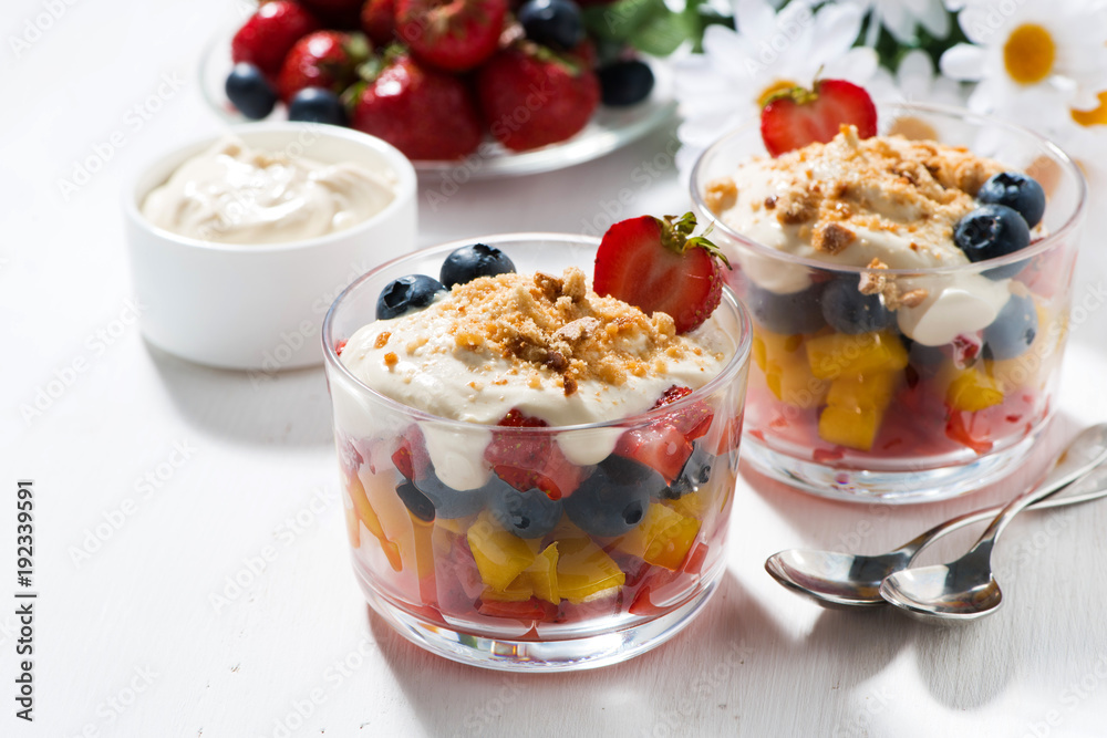 Assorted fresh fruit with custard on white table Assorted fresh fruit with custard on white table