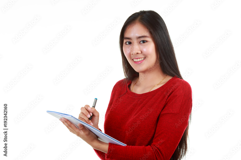 Young Asian woman holding book and taking note with smiling to camre on white background Young Asian woman holding book and taking note with smiling to camre on white background