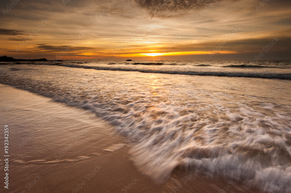 seascape  during golden sunset with waves trails.
