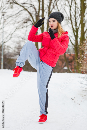 Woman wearing sportswear training boxing outside