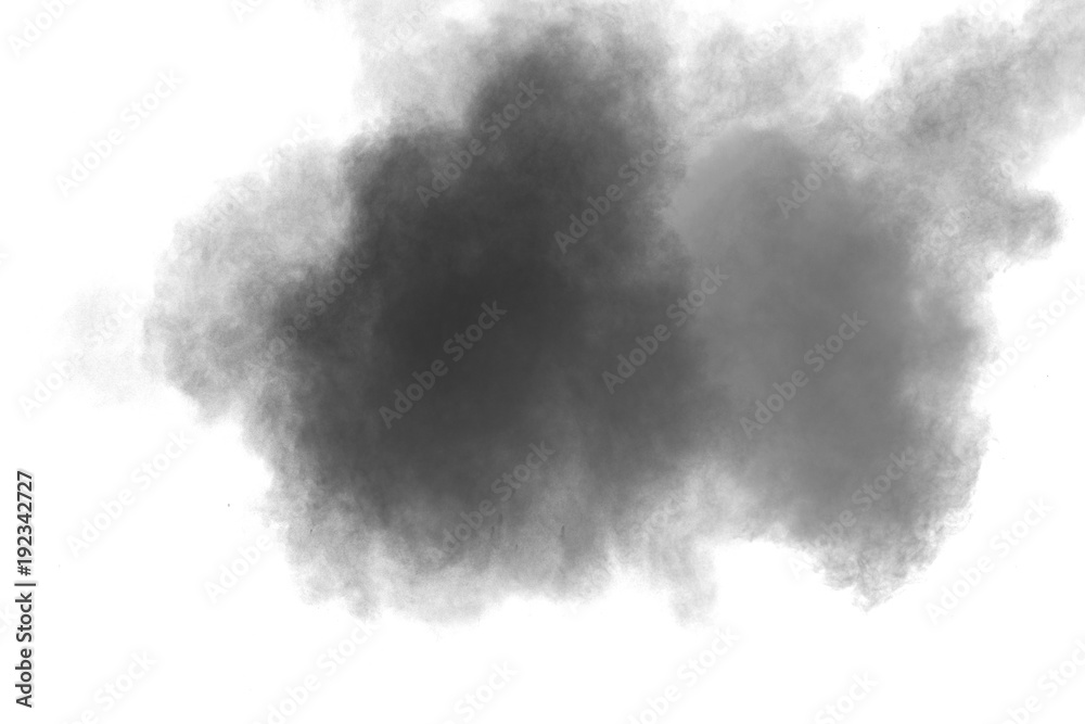 Black powder explosion against white background.The particles of charcoal splatted on white background. Closeup of black dust particles explode isolated on white background.