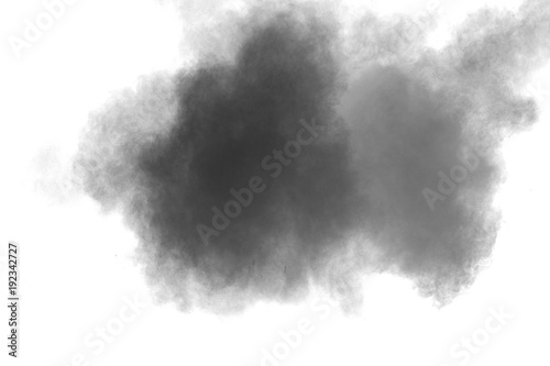 Black powder explosion against white background.The particles of charcoal splatted on white background. Closeup of black dust particles explode isolated on white background.