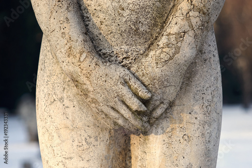 Rzeźba z kamienia, kobiece genitalia przykryte rekami, zbliżenie