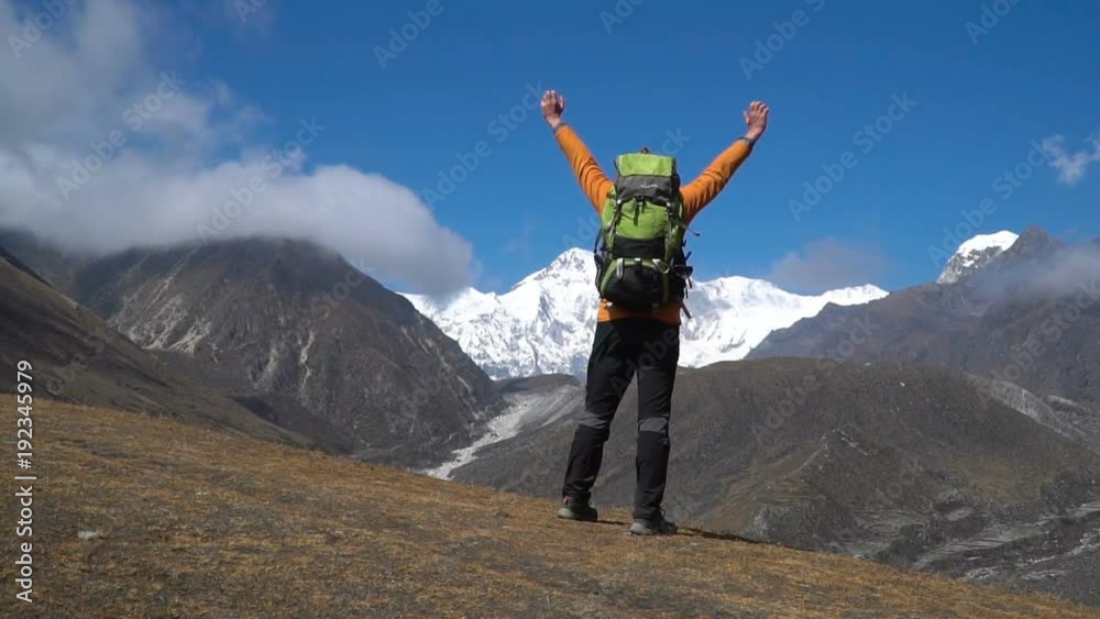 The man reached the top of the mountain in the Himalayas. The tourist laughs and jumps. Enjoys adventure and travel concept. Adventure and travel concept. Slow motion The man reached the top of the mountain in the Himalayas. The tourist laughs and jumps. Enjoys adventure and travel concept. Adventure and travel concept. Slow motion