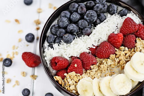 Healthy Breakfast Buddha Bowl with berries, coconut, bananas and granola.