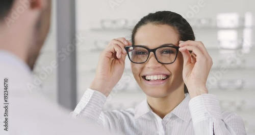 In an optical store, a boy makes a medical examination with the professional equipment to see how many dioptres are missing from sight. Concept of: medical examination, optic, eyes.