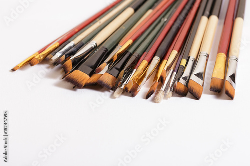 Professional brushes for artists lie on a white canvas