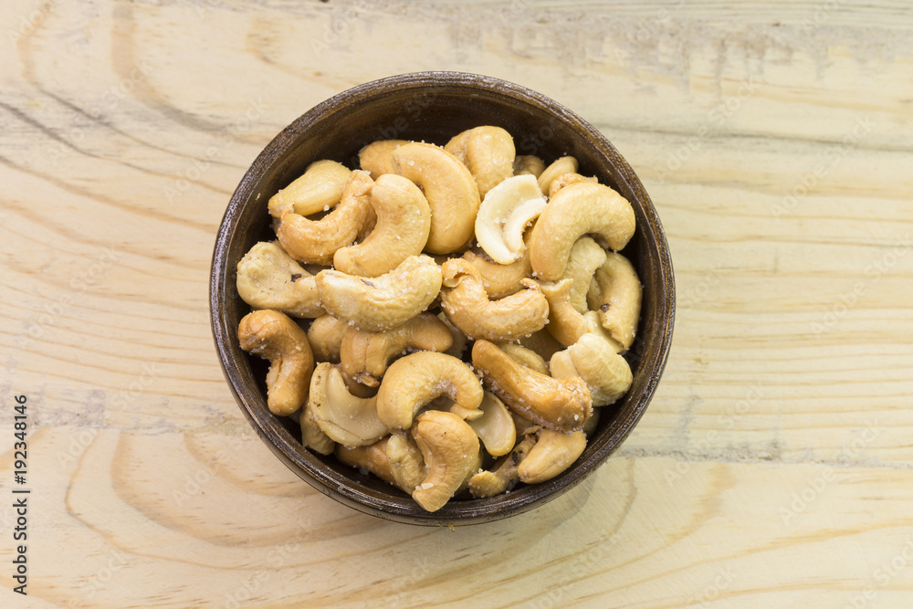 Bowl with cashew nuts on wooden table. Delicacies Bowl with cashew nuts on wooden table. Delicacies