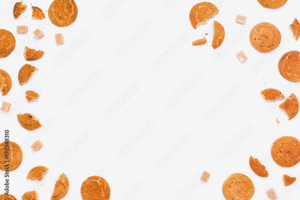Broken cookies and cane sugar cubes on white, copyspace, flatlay frame arrangement Broken cookies and cane sugar cubes on white, copyspace, flatlay frame arrangement