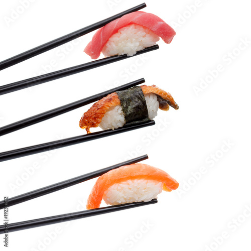 Japanese cuisine. Sushi in chopsticks isolated on white background.
