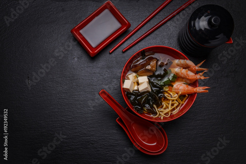 Asian soup with shrimps on a dark wooden table. photo