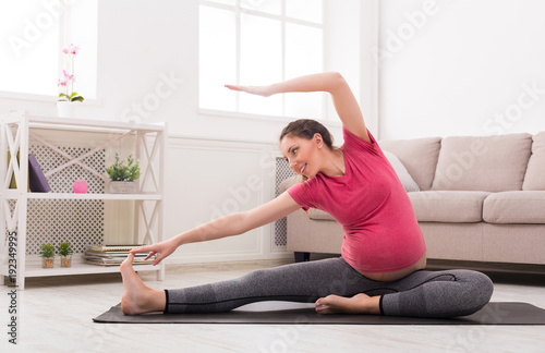 Pregnant woman stretching training indoors