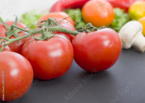 Tomatoes on the table. Red tomatoes lie on the old table. Dietary food. Tomatoes on the table on the background of vegetables.