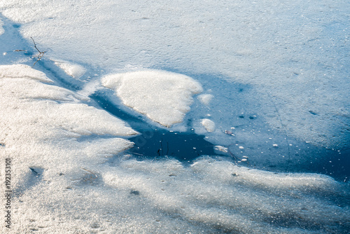 Ein blaues Eisloch im zugefrorenen See © zauberblicke