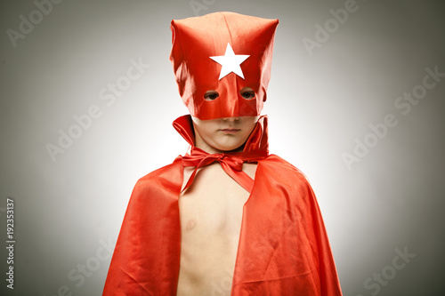 young boy superhero fly with cloak and mask portrait on grey background