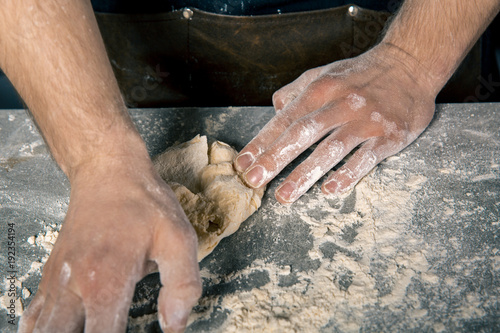 Chef's hands kneading the dough photo