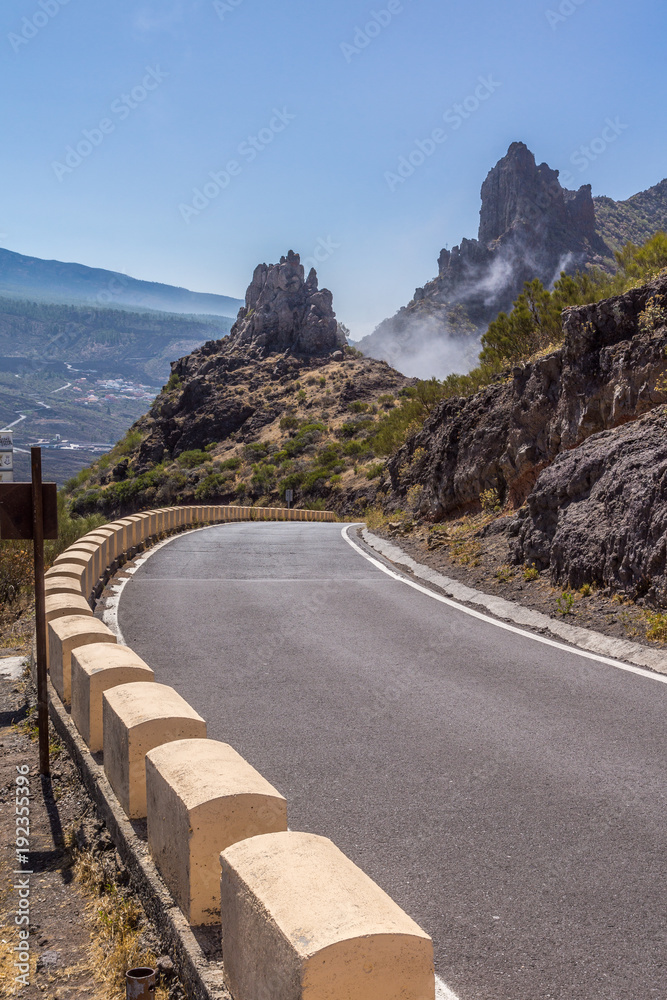 Landstraße mit Straßenbegrenzung durch die schroffen Felsformationen im Teno-Gebirge
