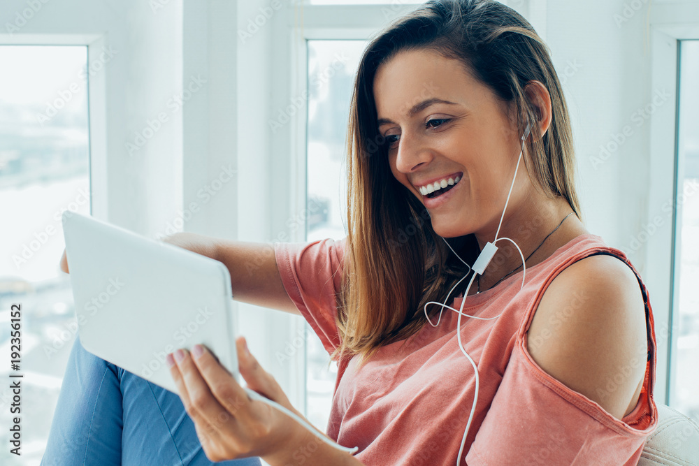 Excited young woman watching movie on tablet Excited young woman watching movie on tablet