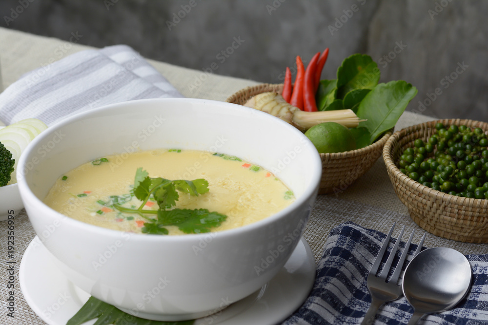 Steamed egg with minced pork recipe in white bowl on the table and gray cement background. Steamed egg with minced pork recipe in white bowl on the table and gray cement background.