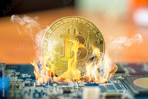 Bitcoin cryptocurrency in the form of a coin burns on fire on a microchip. Concept of death blockchain