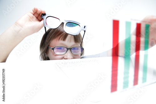 Rehabilitacja wzroku. Mała dziewczynka z okularami czerwono-zielonymi 