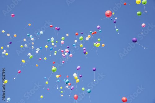 Group of multicolored helium filled balloons in the sky