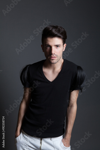handsome young male fashion model posing on gray background in studio