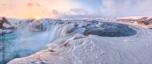 Godafoss frozen waterfall during Winter at sunrise. North Iceland photo