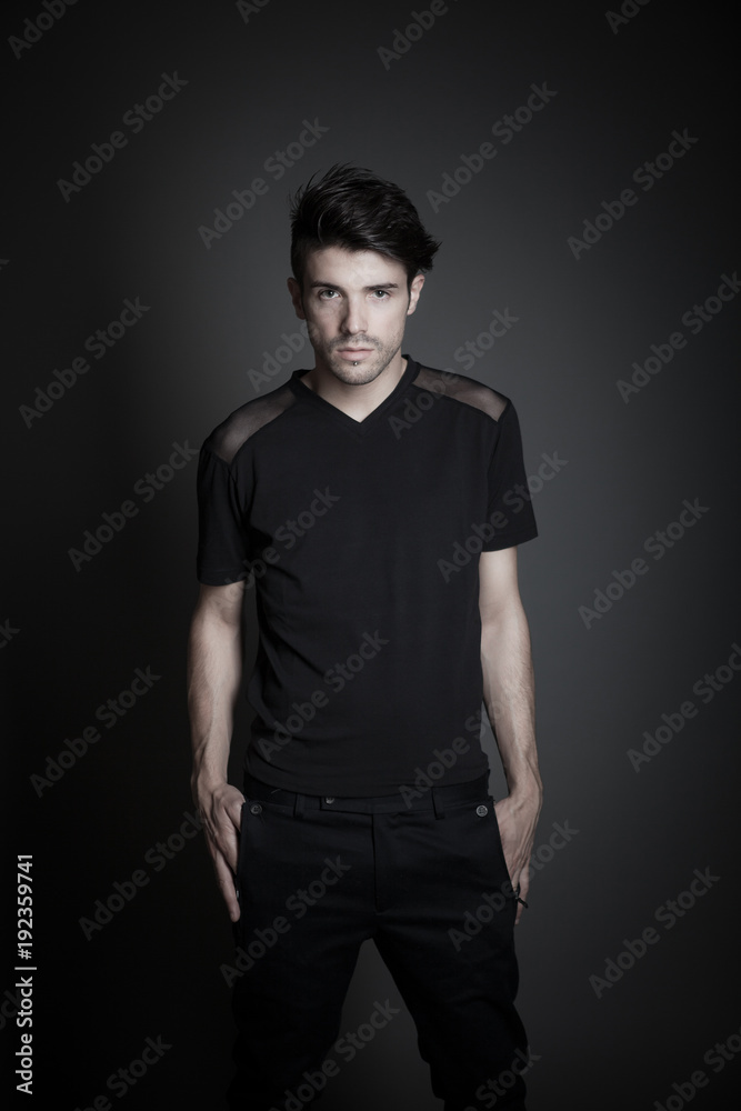 handsome young male fashion model posing on gray background in studio