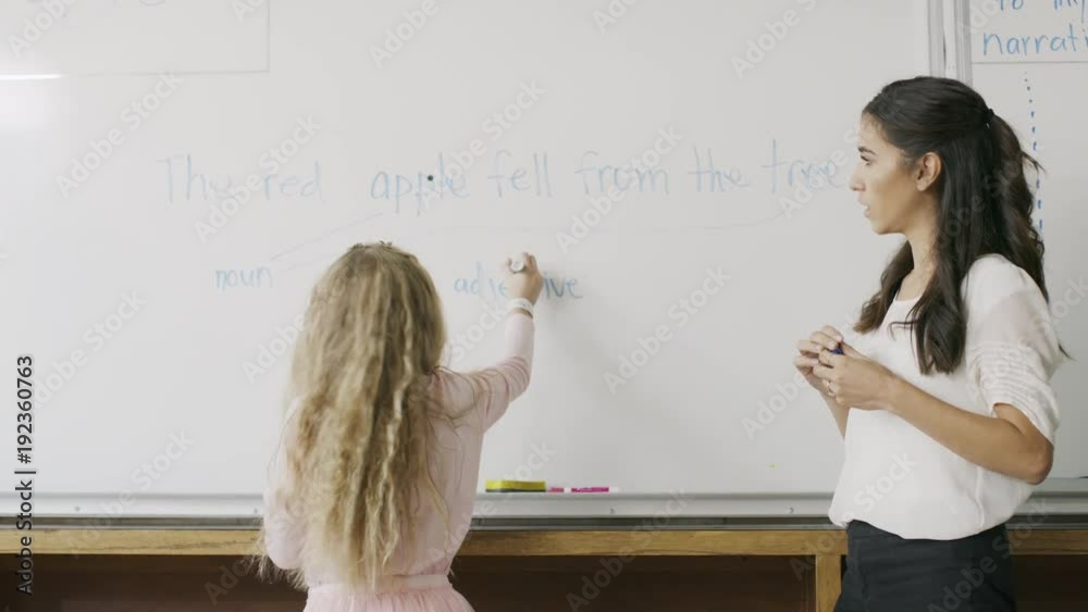 Teacher watching girl at whiteboard in English class / Provo, Utah, United States Teacher watching girl at whiteboard in English class / Provo, Utah, United States