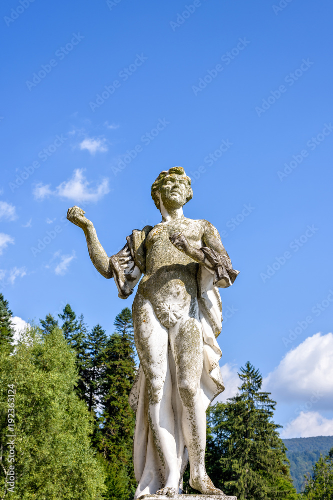 Daylight view from bottom to female statue in garden of Peles castle