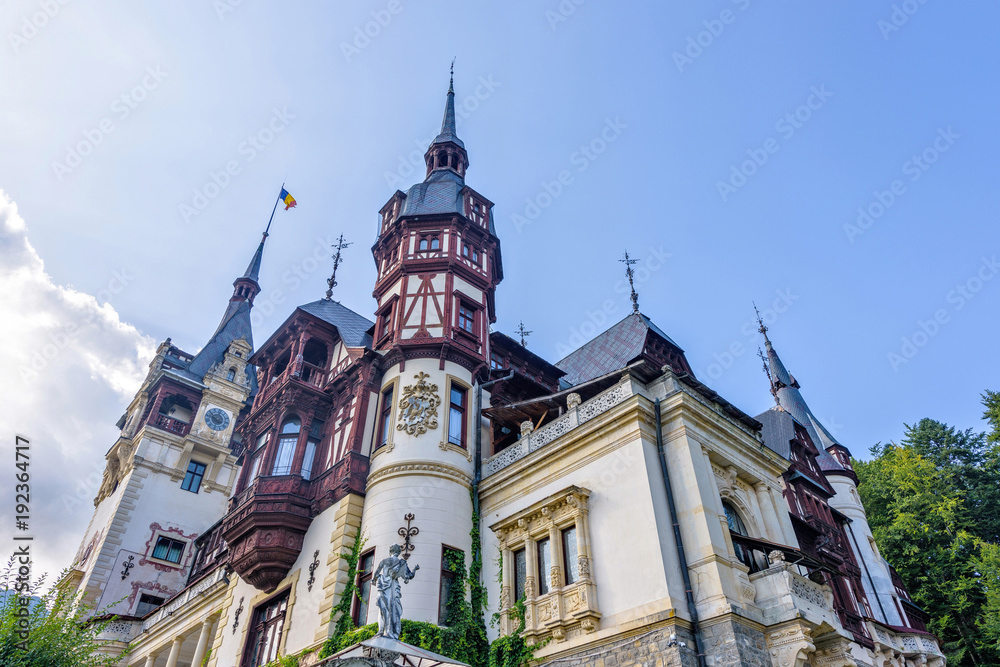 Obraz premium Daylight view from bottom to Peles castle and bright blue sky with clouds