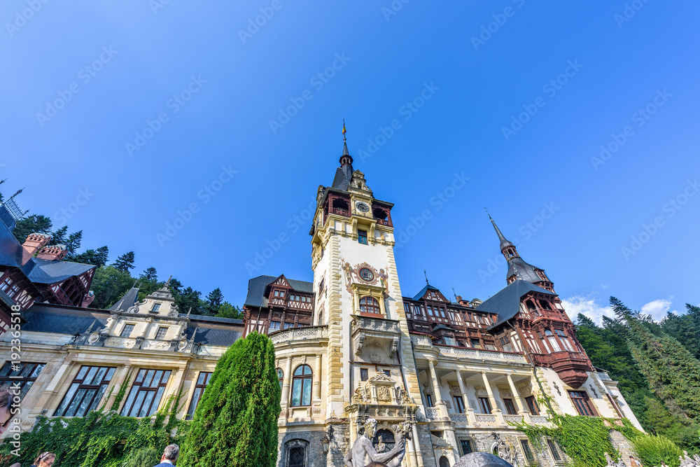 Daylight view from bottom to ornamented facade of Peles castle with tower