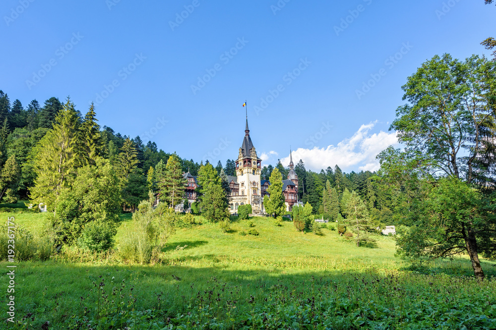 Daylight side far view to Peles castle front facade with hanging flag