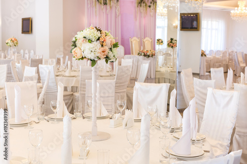 interior, furniture, engagement concept. there is a place decorated with bouquet of flowers and lots of white colour, everything, tables and chaires covered with white textile photo
