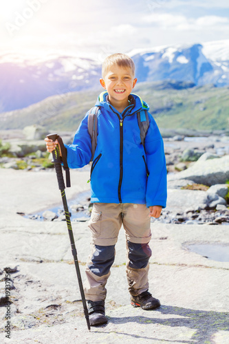 Cute boy with hiking equipment in the mountains